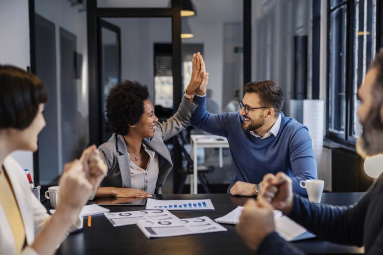 Personas reunidas en una oficina y celebrando